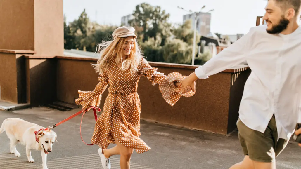 man and woman walking dog
