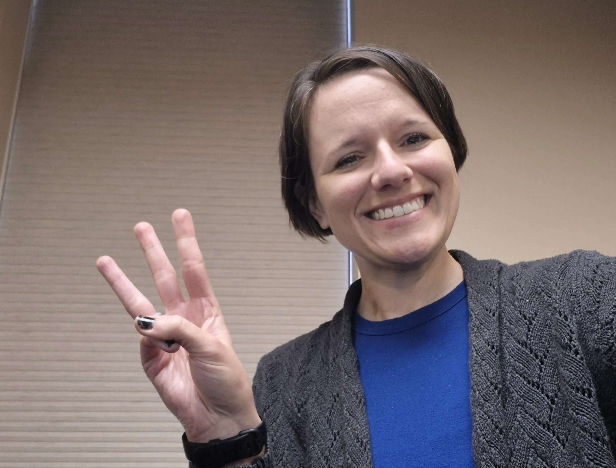 woman holds up 3 fingers
