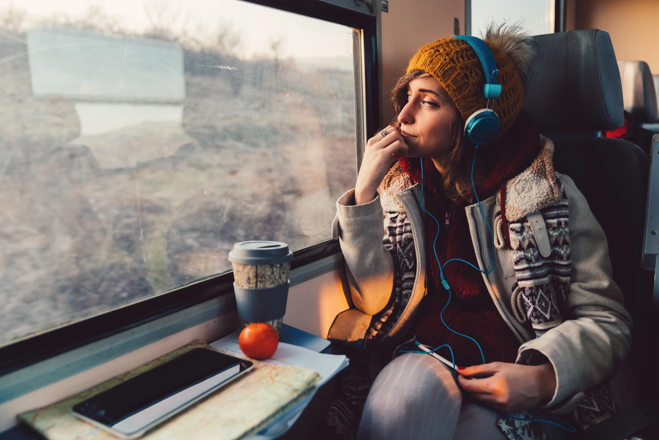 Female riding train and listening on headphones