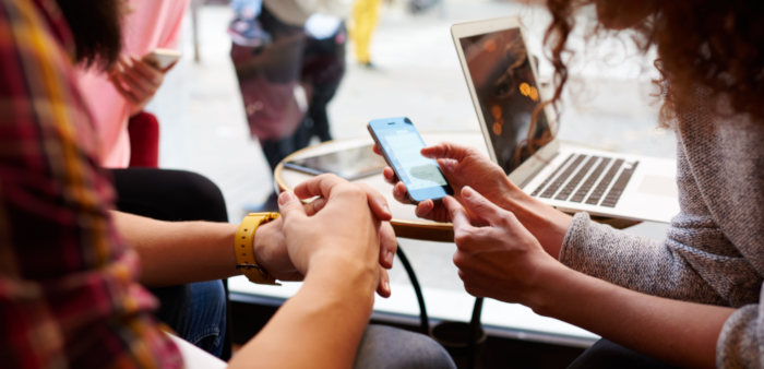 Person showing cell phone to another person.