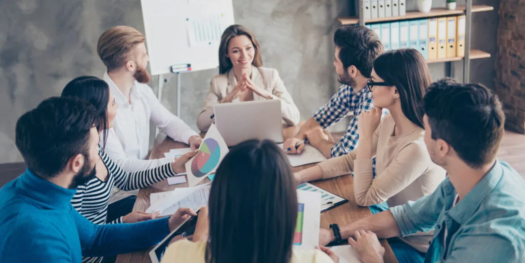 Group of marketers sitting around a conference room table.
