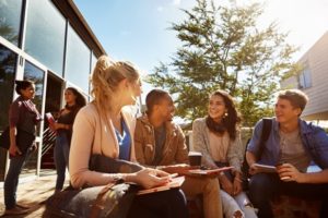 Group of students talking together and enjoying the sunshine