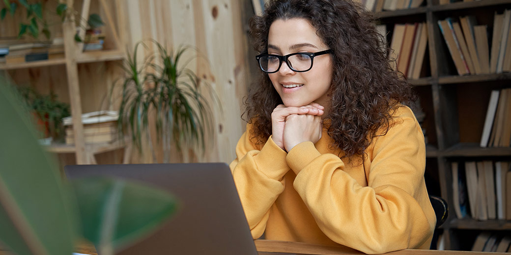 Young woman reading off her laptop