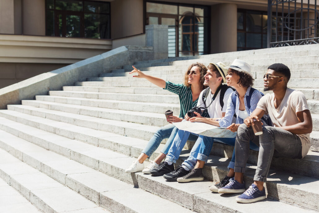 four students talking together on the steps of a campus building
