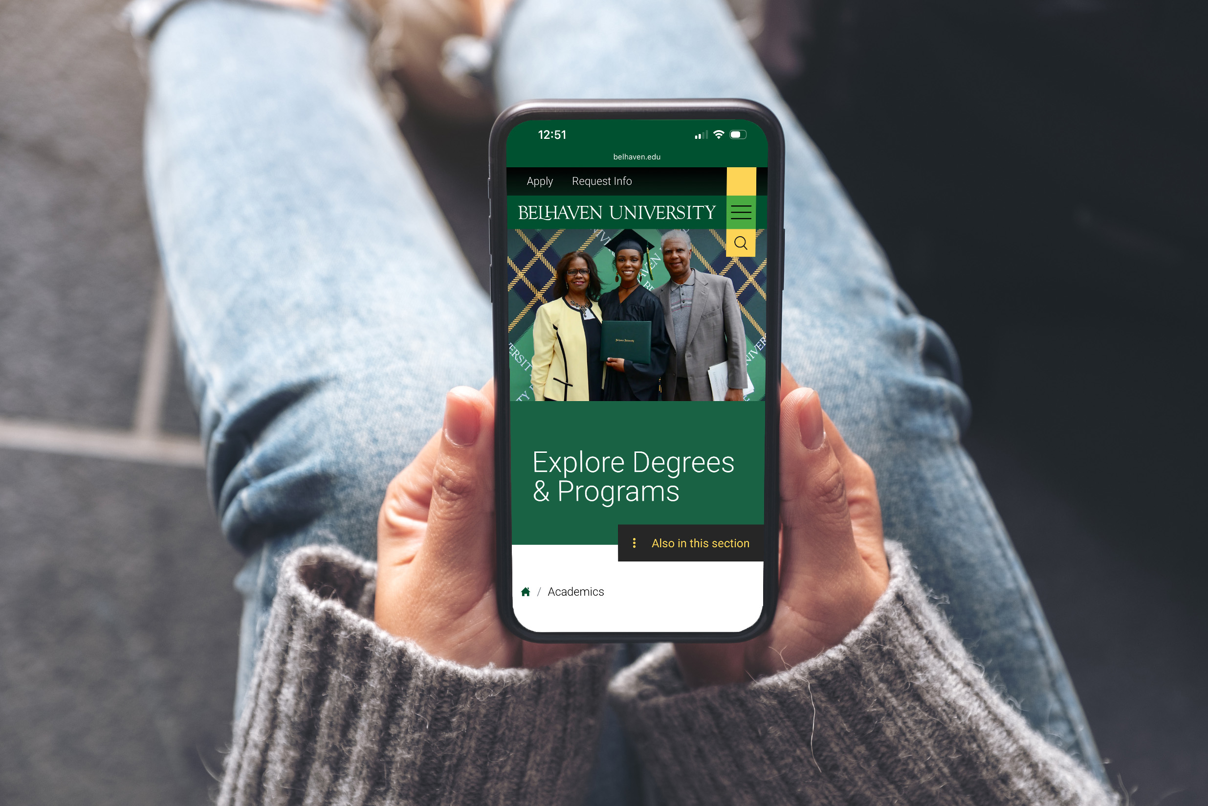 Person holding mobile device showing Belhaven mobile website