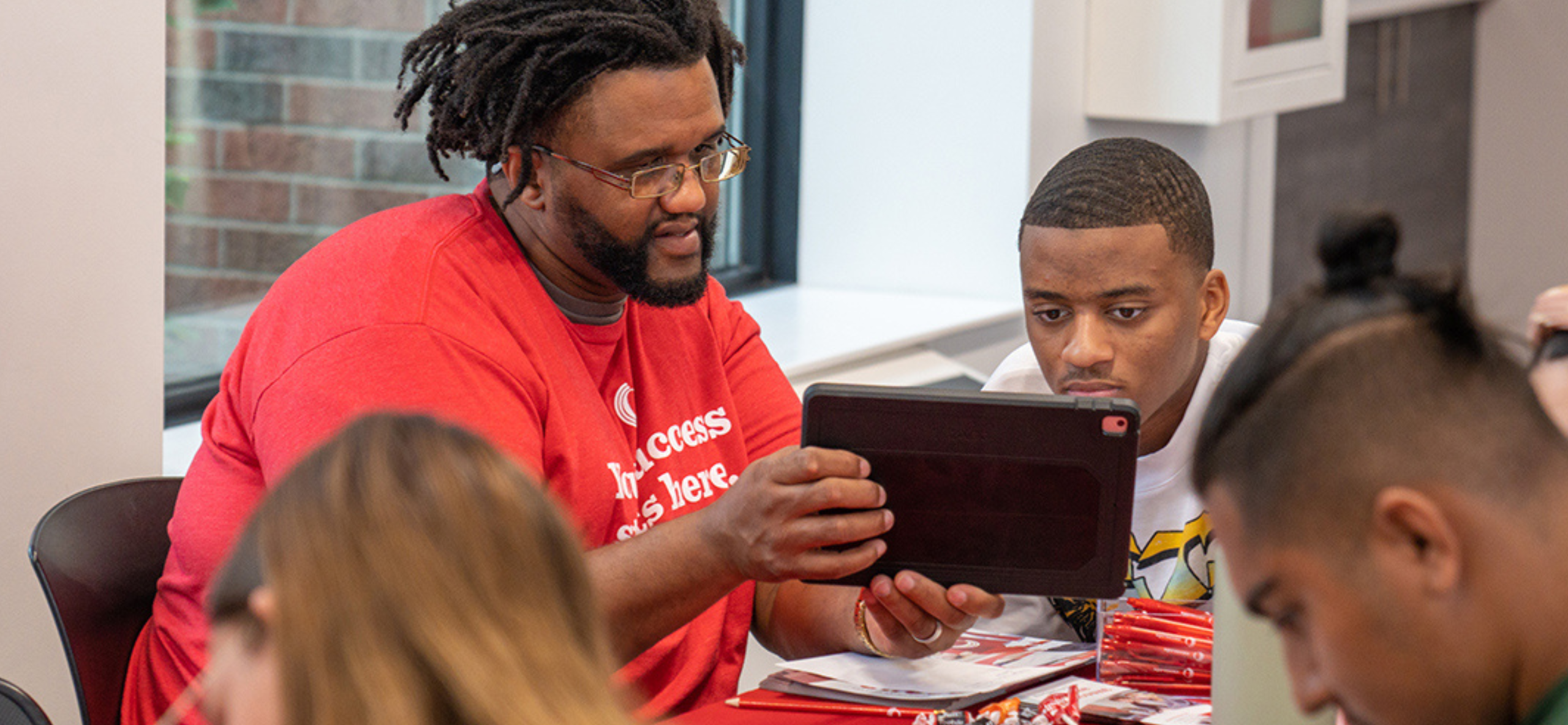 Owens Community College staff member showing a student information on a tablet during an advising or orientation session