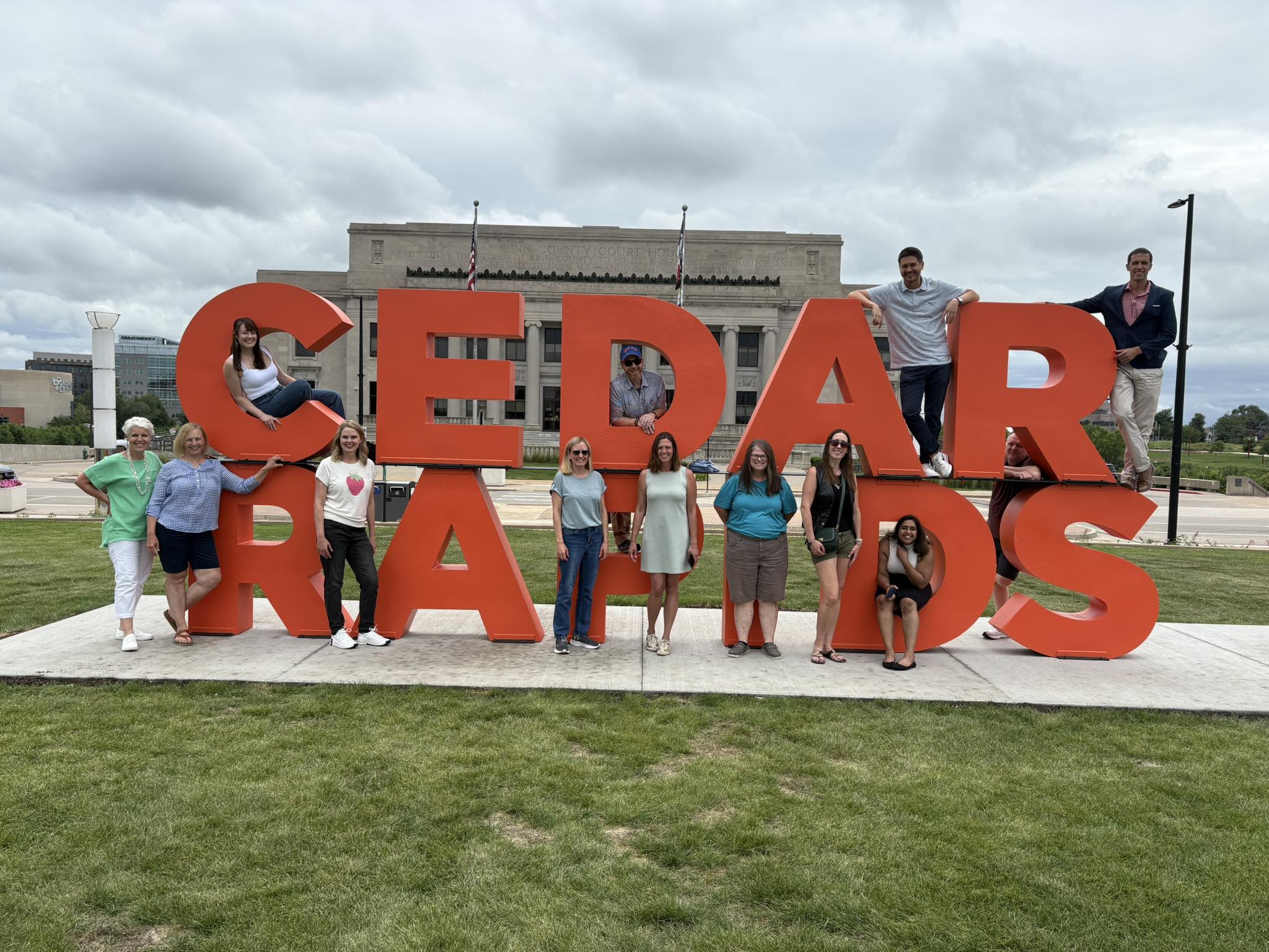 Stamats team by a Cedar Rapids sign