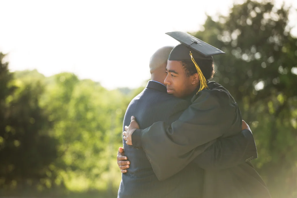 man hugging son who is graduating.